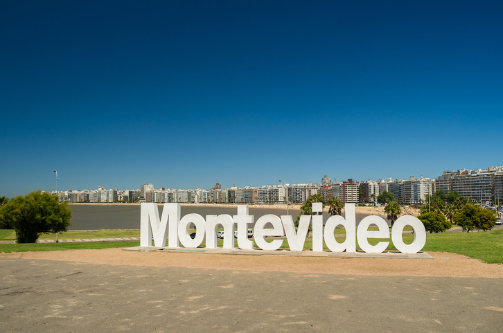 Der große Schriftzug "Montevideo" steht auf einer Grünfläche vor der Skyline der Stadt.