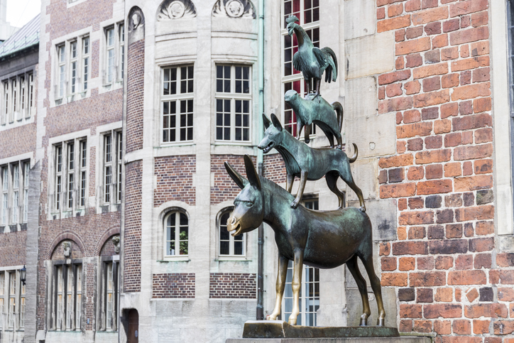 Die berühmte Bronzestatue der Stadtmusikanten – Esel, Hund, Katze und Hahn – steht vor einer historischen Backsteinfassade.
