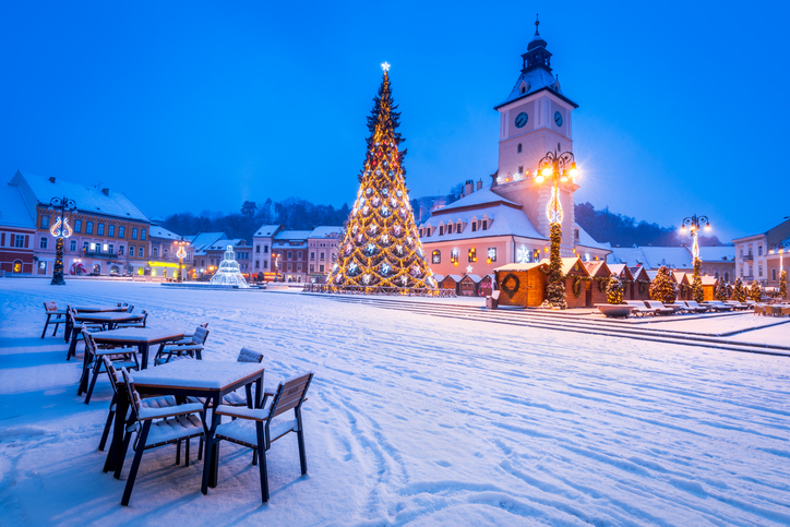 Beleuchteter Weihnachtsbaum und verschneiter Rathausplatz in Brașov