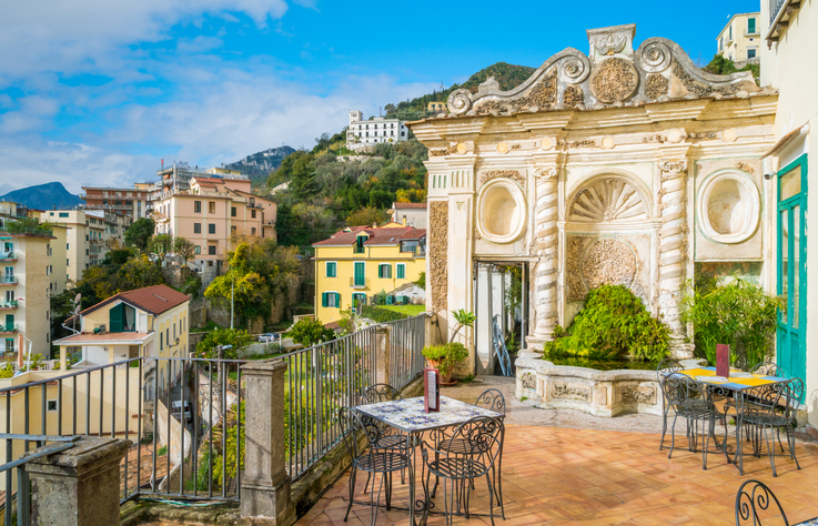 Verzierte Terrasse mit Brunnen und Blick auf Häuser und Hügel in Salerno