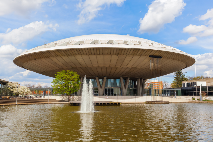 Das runde Gebäude Evoluon in Eindhoven mit Wasserbecken im Vordergrund.