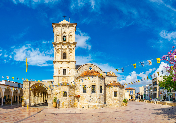 Historische Steinkirche mit Glockenturm auf einem offenen Platz in Larnaka