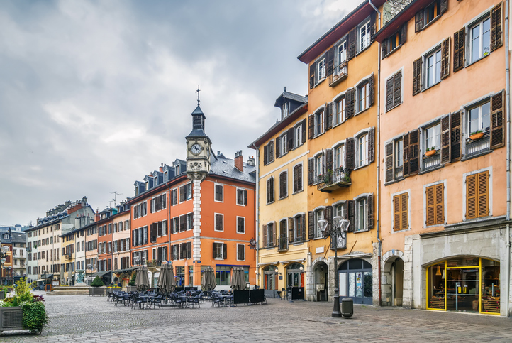 Historische Häuser mit bunten Fassaden, Uhrturm und Straßencafés in Chambéry