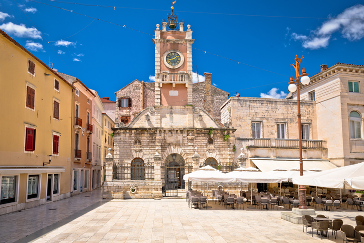 Der Volksplatz in Zadar mit historischem Uhrturm, hellen Fassaden und Straßencafés.