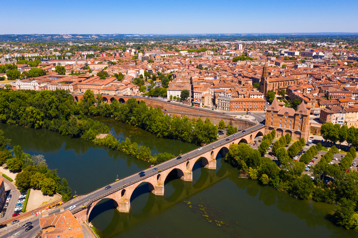Luftbild von Montauban mit Pont Vieux, Fluss Tarn, Bäumen und Altstadt.