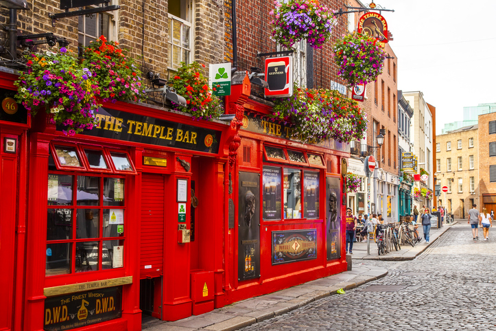 Die rote Fassade des berühmten Pubs Temple Bar steht an einer gepflasterten Straße in Dublin.