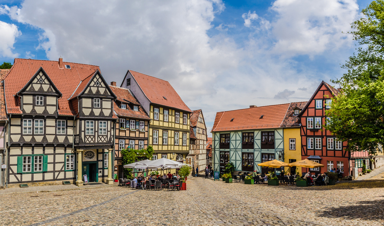 Ein weiter Platz mit bunten Fachwerkhäusern und Kopfsteinpflaster liegt in Quedlinburg.