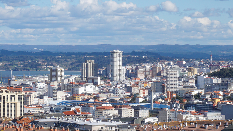 Blick über die Dächer und Hochhäuser von A Coruña mit Hügeln im Hintergrund