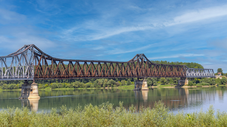 Lange Stahlbrücke über einen breiten Fluss mit grünem Ufer und blauem Himmel bei Šabac