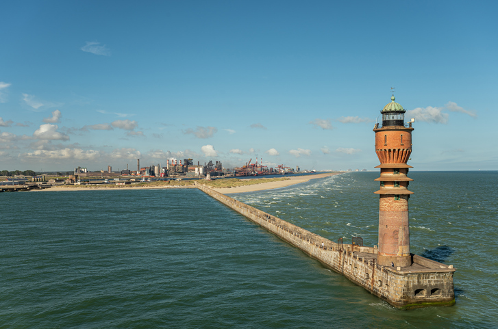 Ein Leuchtturm steht am Ende einer langen Mole vor der Küste von Dunkerque.