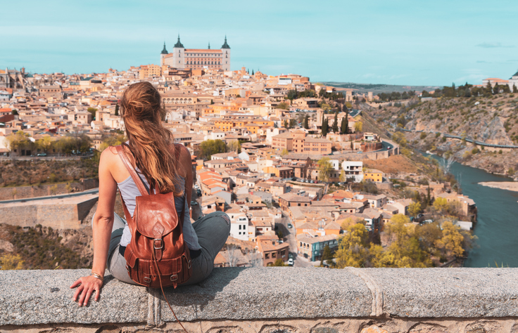 Reisende blickt über Toledo mit Alcázar, historischen Häusern und dem Fluss Tajo
