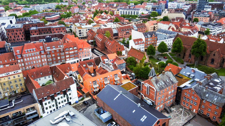 Luftaufnahme von Odense mit roten Dächern, Kirchen und historischen Gebäuden im Stadtzentrum.