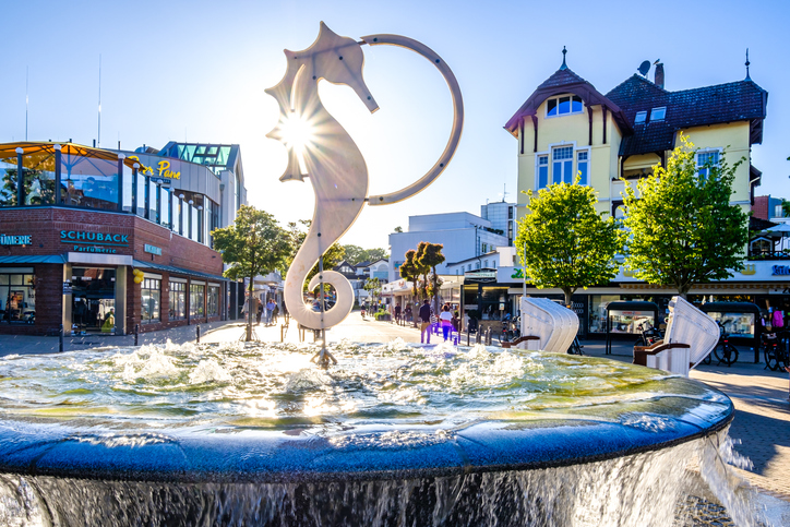 Brunnen mit Seepferdchen-Skulptur im Zentrum von Timmendorfer Strand bei Sonnenschein.
