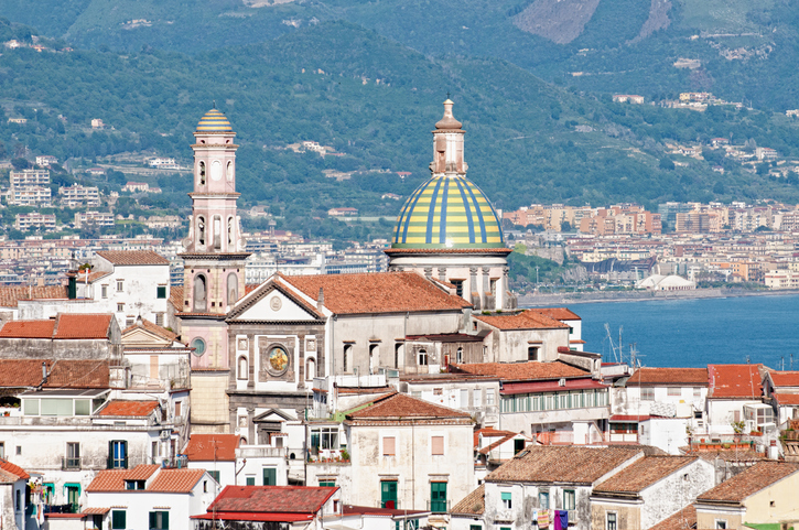 Altstadtdächer, Kirchtürme und bunte Kuppel mit Blick auf das Meer in Salerno