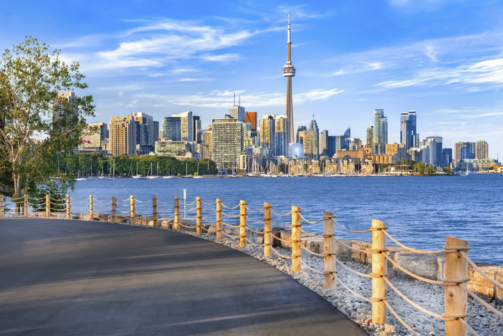 Uferpromenade mit Blick auf die Skyline von Toronto und den CN Tower am Wasser.