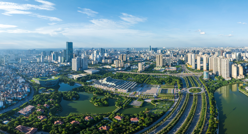 Luftaufnahme von Hanoi mit moderner Skyline, breiten Straßen, Grünflächen und dicht bebautem Stadtgebiet.
