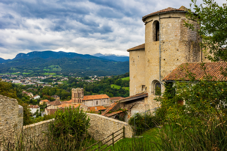 Historische Gebäude und Dächer in Saint-Girons mit grünem Tal und Bergen im Hintergrund