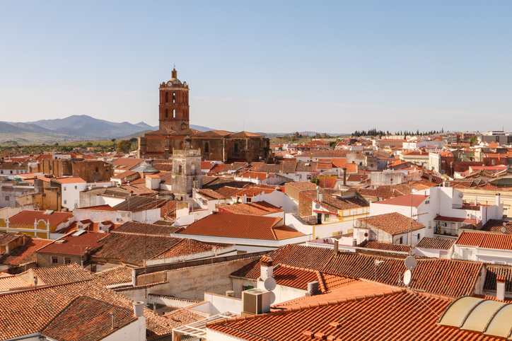 Dächer einer historischen Stadt mit Kirche und weitem Blick über die Landschaft in der Provinz Badajoz