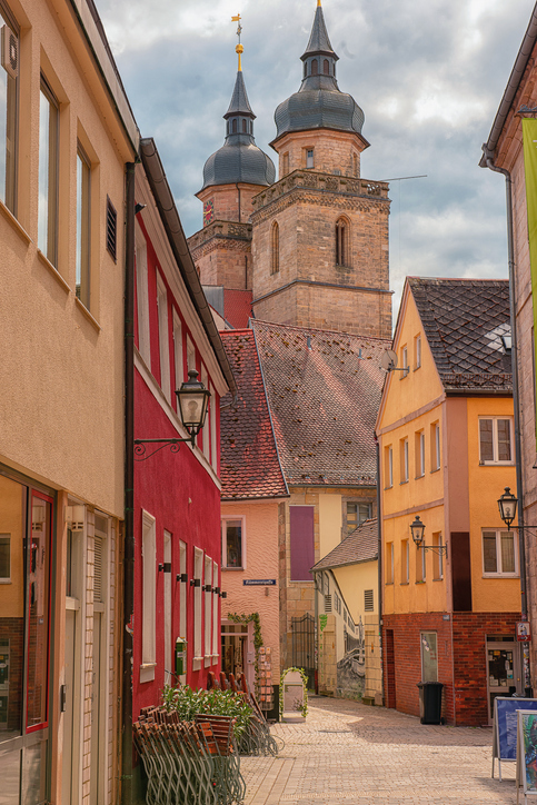 Enge Gasse mit farbigen Häusern und den Türmen der Stadtkirche von Bayreuth