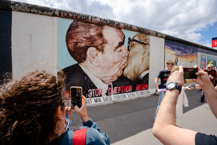 Besucher fotografieren das berühmte Bruderkuss-Mural an der East Side Gallery in Berlin.