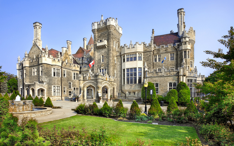 Historisches Schloss Casa Loma in Toronto mit Türmen, Garten und steinerner Fassade.
