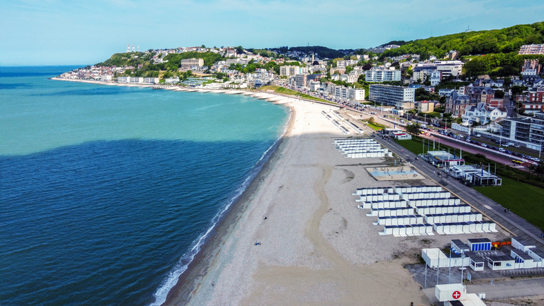 Der breite Strand von Le Havre erstreckt sich entlang der Küste mit Stadtblick im Hintergrund.