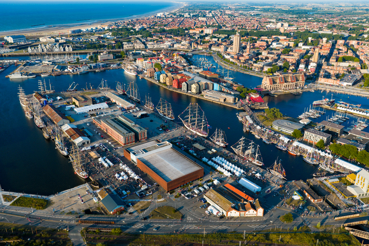 Weite Luftaufnahme von Dunkerque mit Hafenbecken, Stadtvierteln und Küstenlinie.