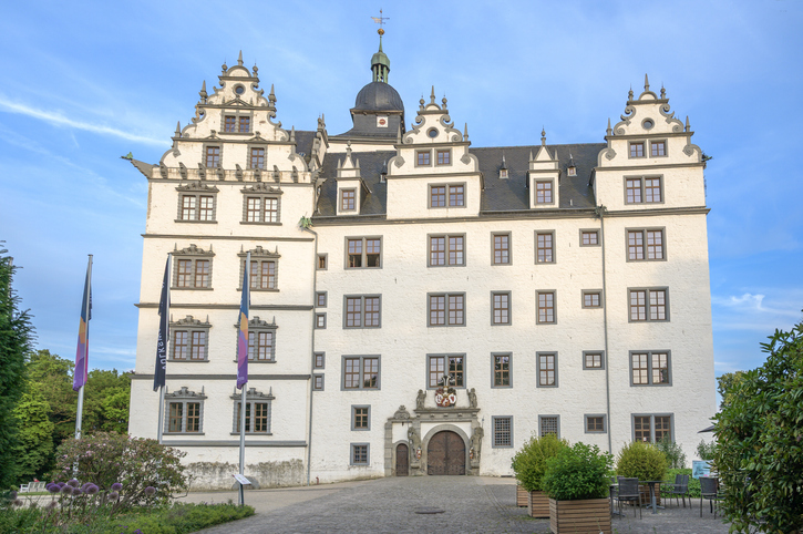 Die helle Fassade von Schloss Wolfsburg mit Türmen, Giebeln, Innenhof und historischem Eingang.