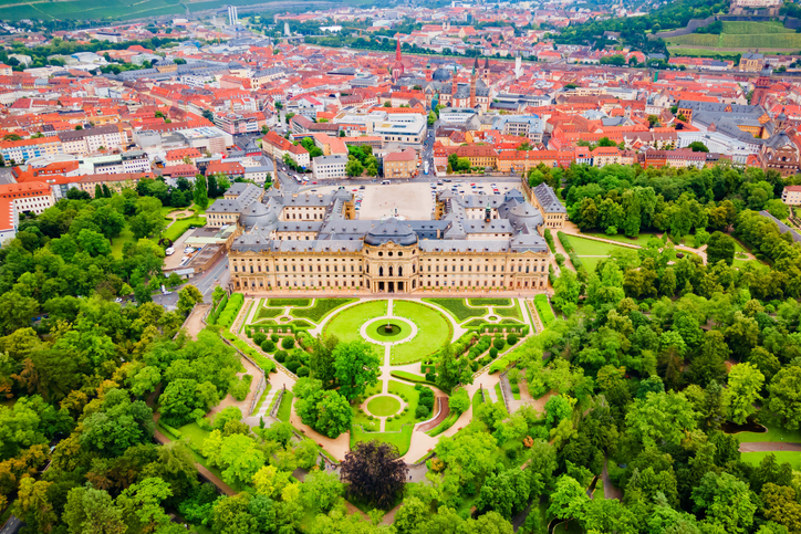 Luftaufnahme der Würzburger Residenz mit Gartenanlage und Blick über die Stadt.