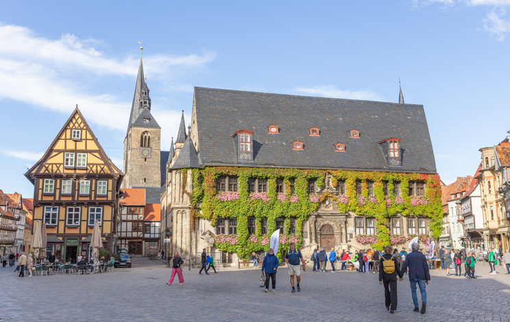 Das historische Rathaus und Fachwerkhäuser stehen am Marktplatz von Quedlinburg.