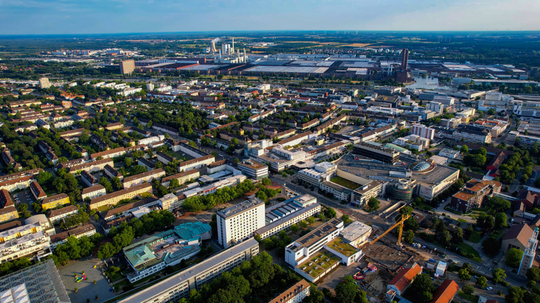 Luftaufnahme von Wolfsburg mit Stadtzentrum, Autostadt, Volkswagenwerk und viel Grün in der Umgebung.