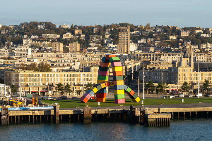 Eine bunte Container-Skulptur steht am Wasser vor der Stadt Le Havre.