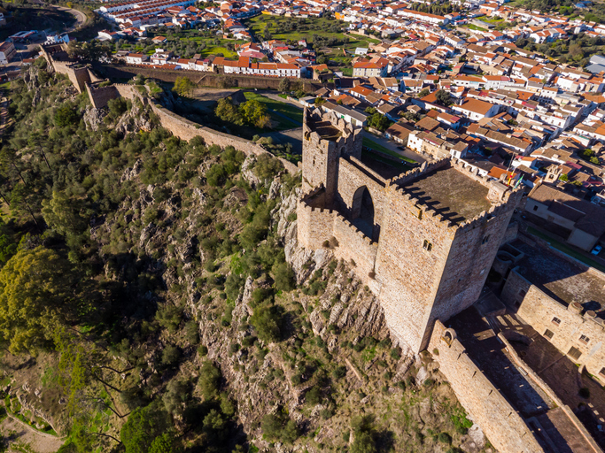 Luftaufnahme einer alten Festung auf einem Hügel oberhalb einer Stadt in der Provinz Badajoz