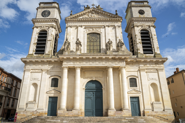 Fassade der Kathedrale von Montauban mit zwei Türmen, Statuen und großen Portalen.