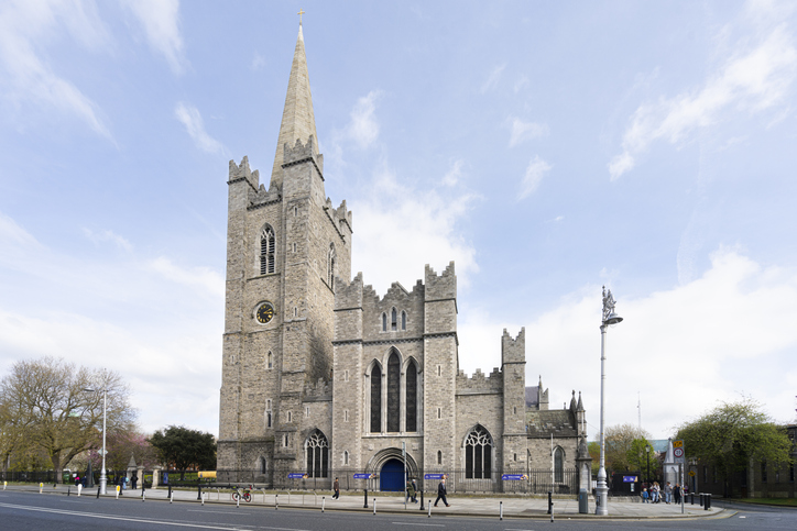 Die Christ Church Cathedral in Dublin steht an einer breiten Straße unter hellem Himmel.