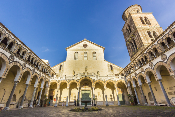 Arkadenhof und Glockenturm des Doms von Salerno unter blauem Himmel