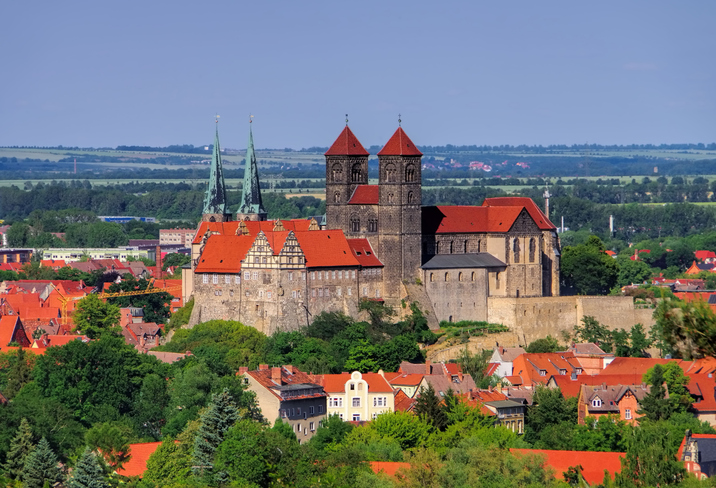 Die Stiftskirche auf dem Schlossberg erhebt sich über den roten Dächern von Quedlinburg.
