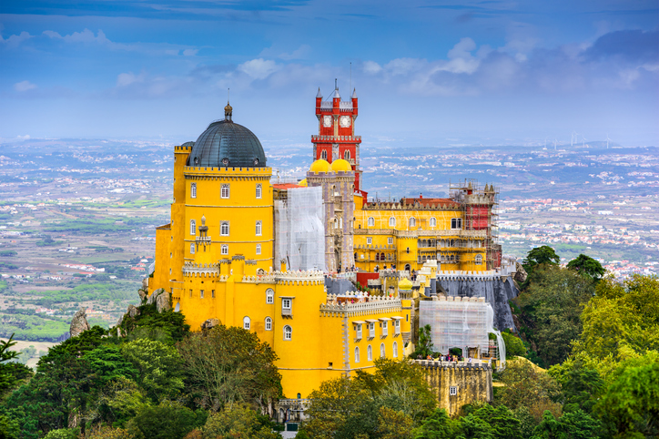 Der gelbe Palácio da Pena thront auf einem bewaldeten Hügel über der Landschaft von Sintra.