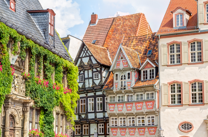 Bunte Fachwerkhäuser mit roten Dächern prägen eine historische Straße in Quedlinburg.