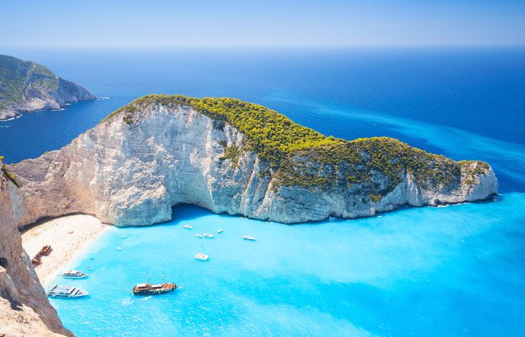 Große Bucht mit weißen Felsen, hellem Strand und türkisfarbenem Wasser am Navagio Beach auf Zakinthos
