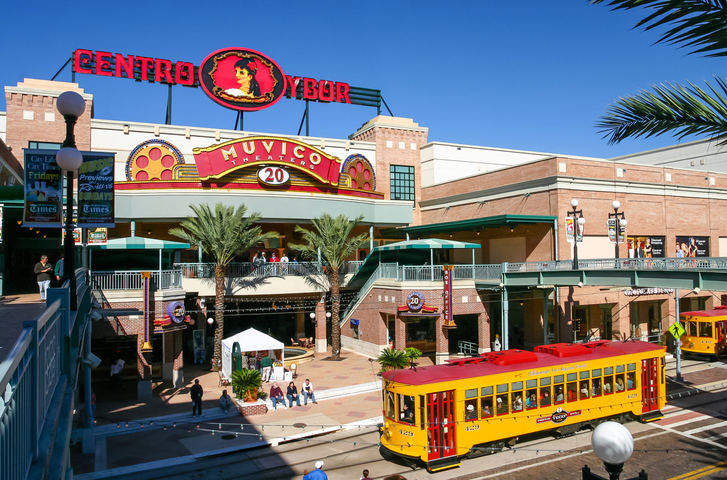 Eine gelbe Straßenbahn fährt vor dem Centro Ybor im historischen Viertel von Tampa.