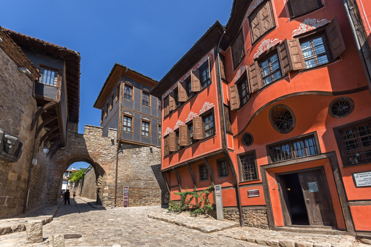 Historische Häuser mit roten Fassaden und eine steinerne Gasse an der alten Stadtmauer in Plowdiw.