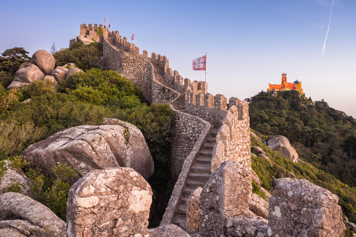 Die steinerne Mauer des Castelo dos Mouros führt über den Hügel, im Hintergrund ist der Palácio da Pena zu sehen.