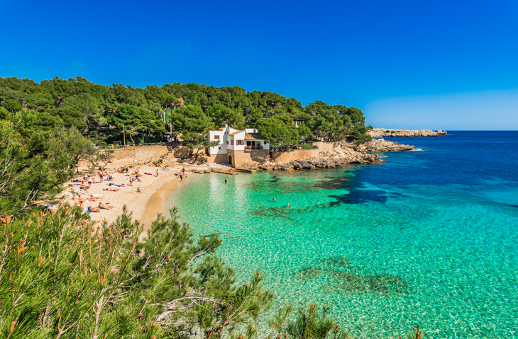 Sandstrand und türkisblaues Wasser in der Bucht von Cala Gat