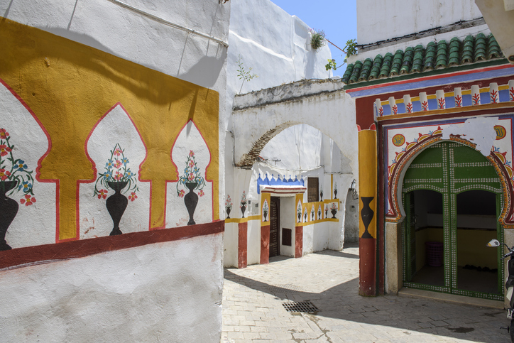 Enge Gasse mit bunt bemalten Wänden und verziertem Eingang in Tetouan