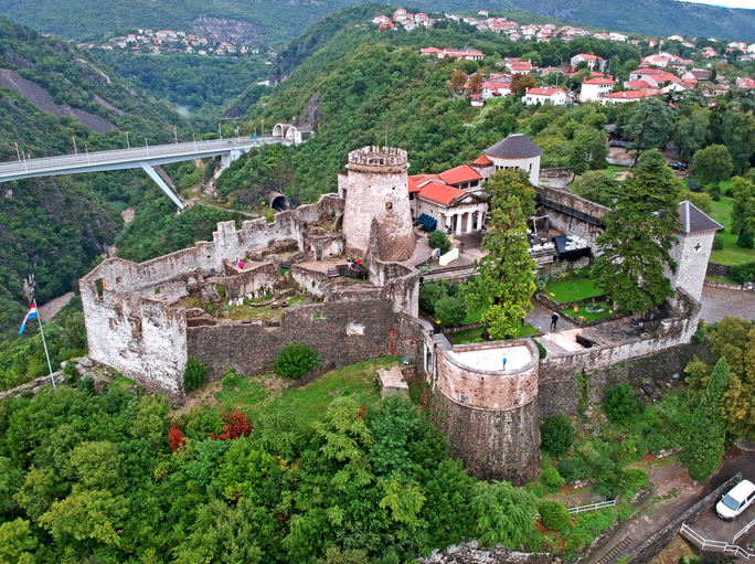 Luftaufnahme einer alten Burganlage auf einem bewaldeten Hügel oberhalb von Rijeka