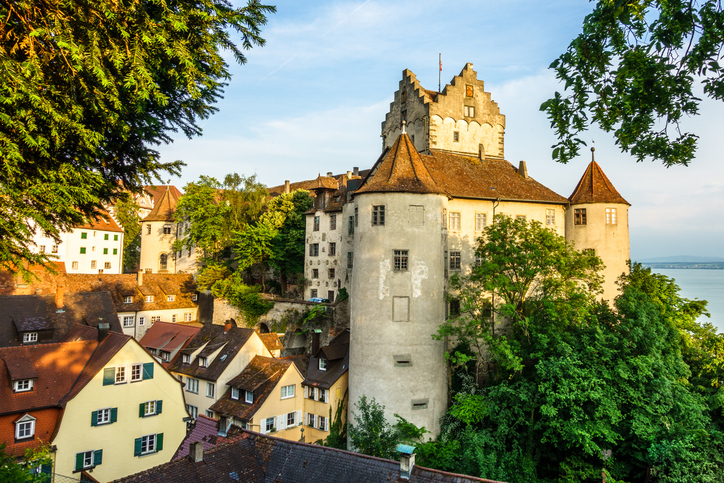 Ein historisches Burggebäude mit Türmen erhebt sich über den Dächern von Meersburg.