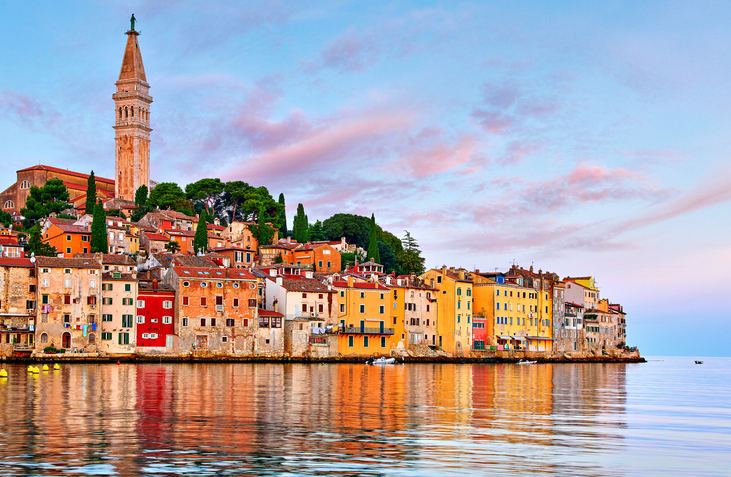 Uferansicht von Rovinj mit bunten Häusern und Kirchturm im warmen Abendlicht