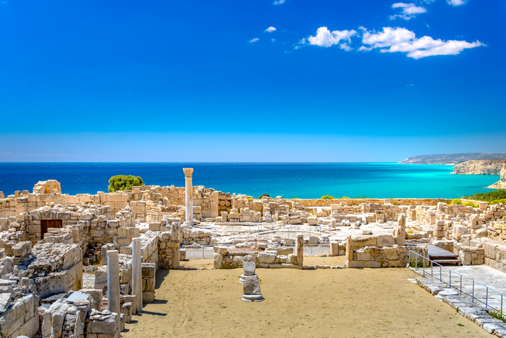 Weitläufige antike Ausgrabungsstätte bei Limassol mit Säulen, Steinmauern und türkisblauem Mittelmeer im Hintergrund.