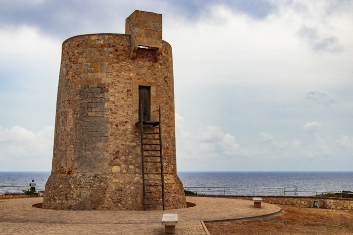 Alter runder Wachturm aus Naturstein an der Küste bei Cala Santanyí